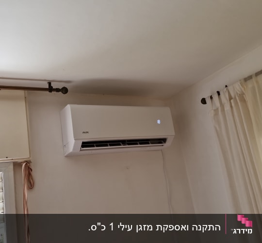 מזגן מותקן על קיר בחדר עם וילונות